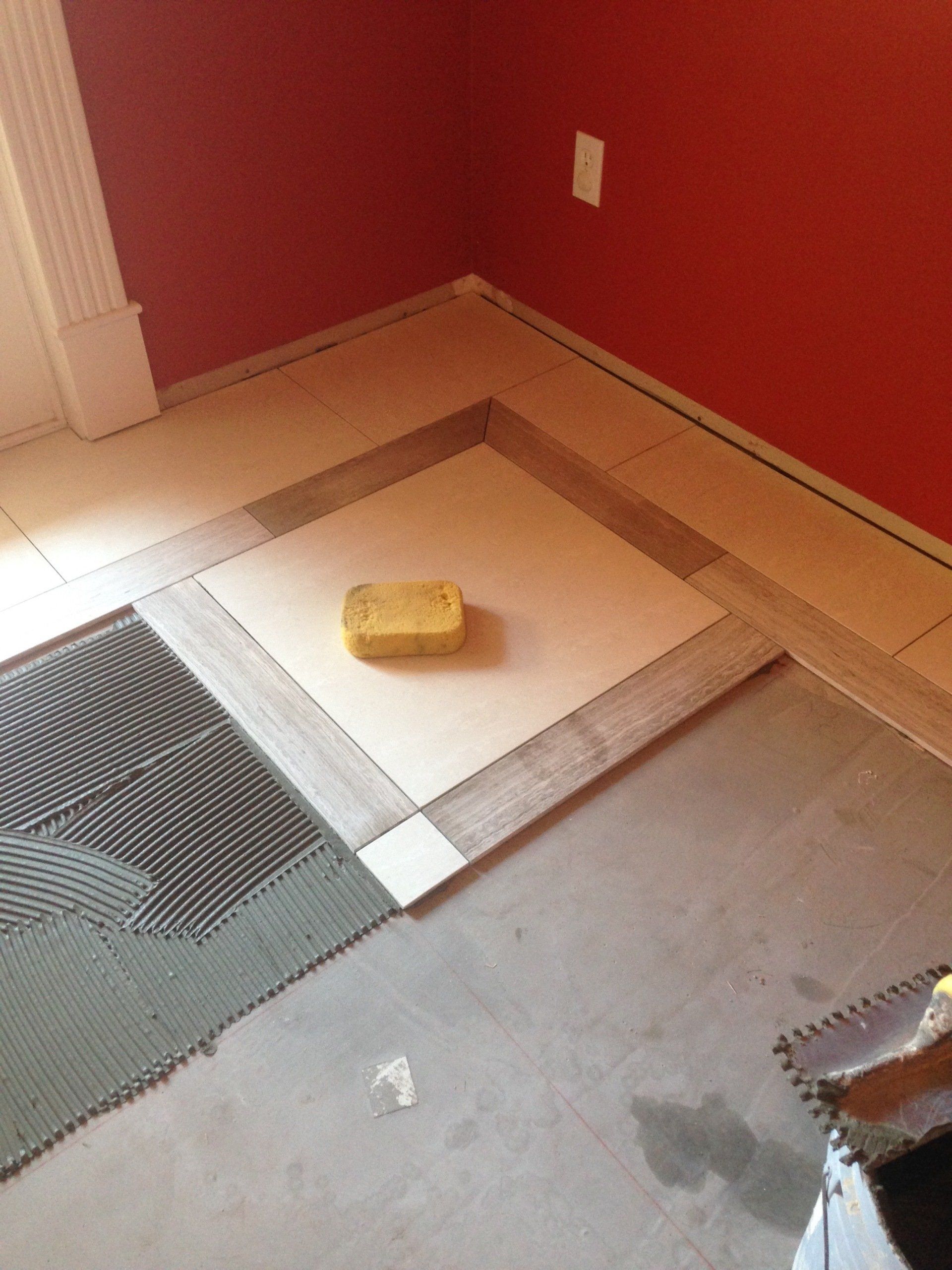 A yellow sponge is sitting on a tiled floor in a room.