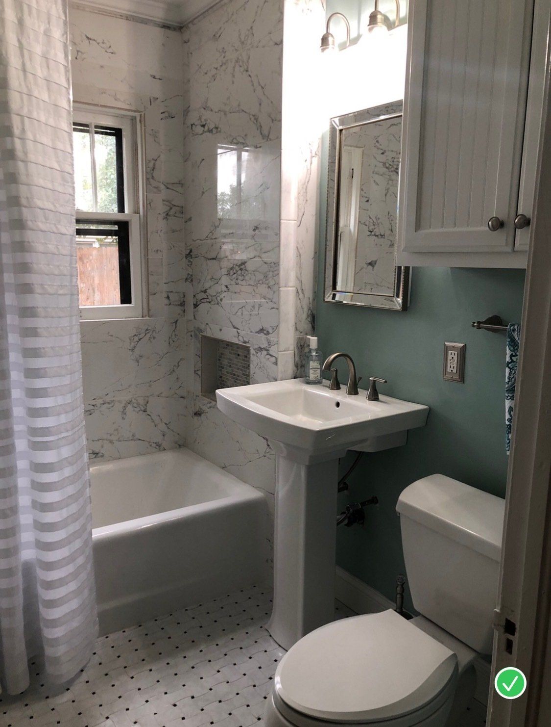 A bathroom with a sink , toilet , tub and mirror.
