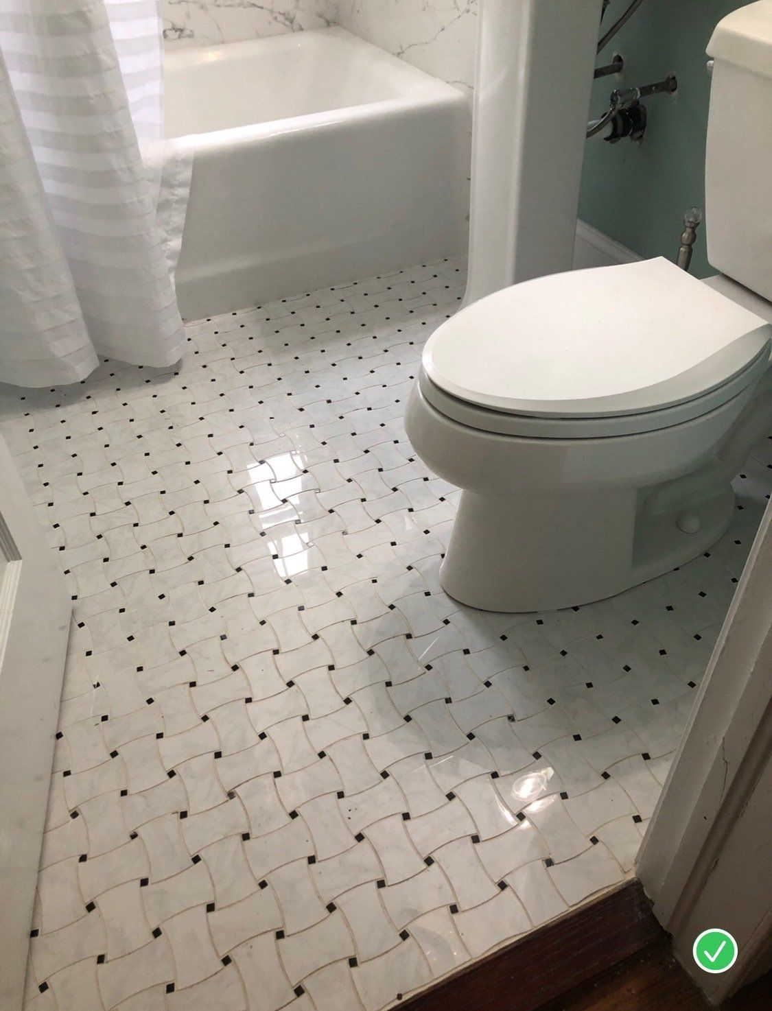 A bathroom with a toilet , tub and shower.