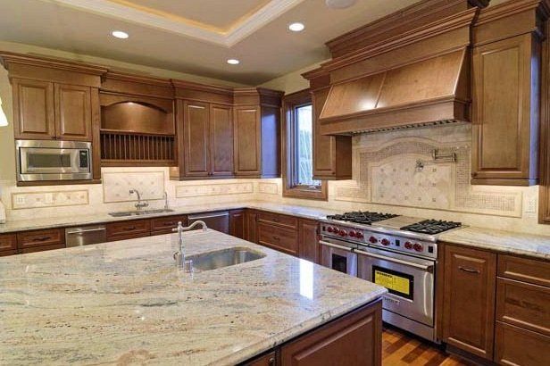 A kitchen with stainless steel appliances and granite counter tops.