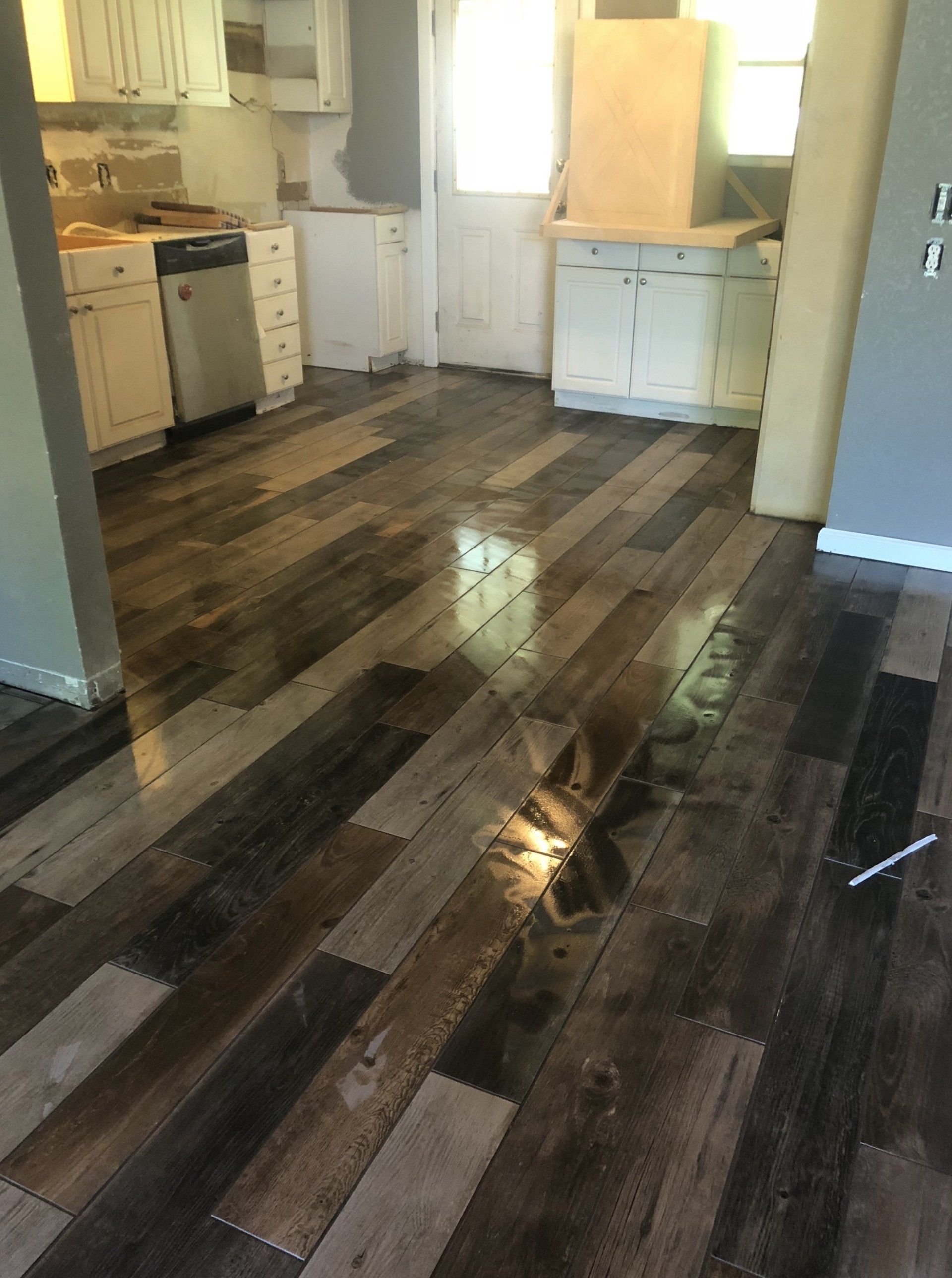 A kitchen with a wooden floor and white cabinets.