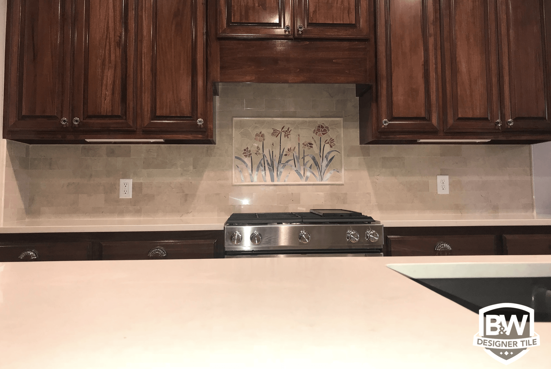A kitchen with stainless steel appliances and wooden cabinets.