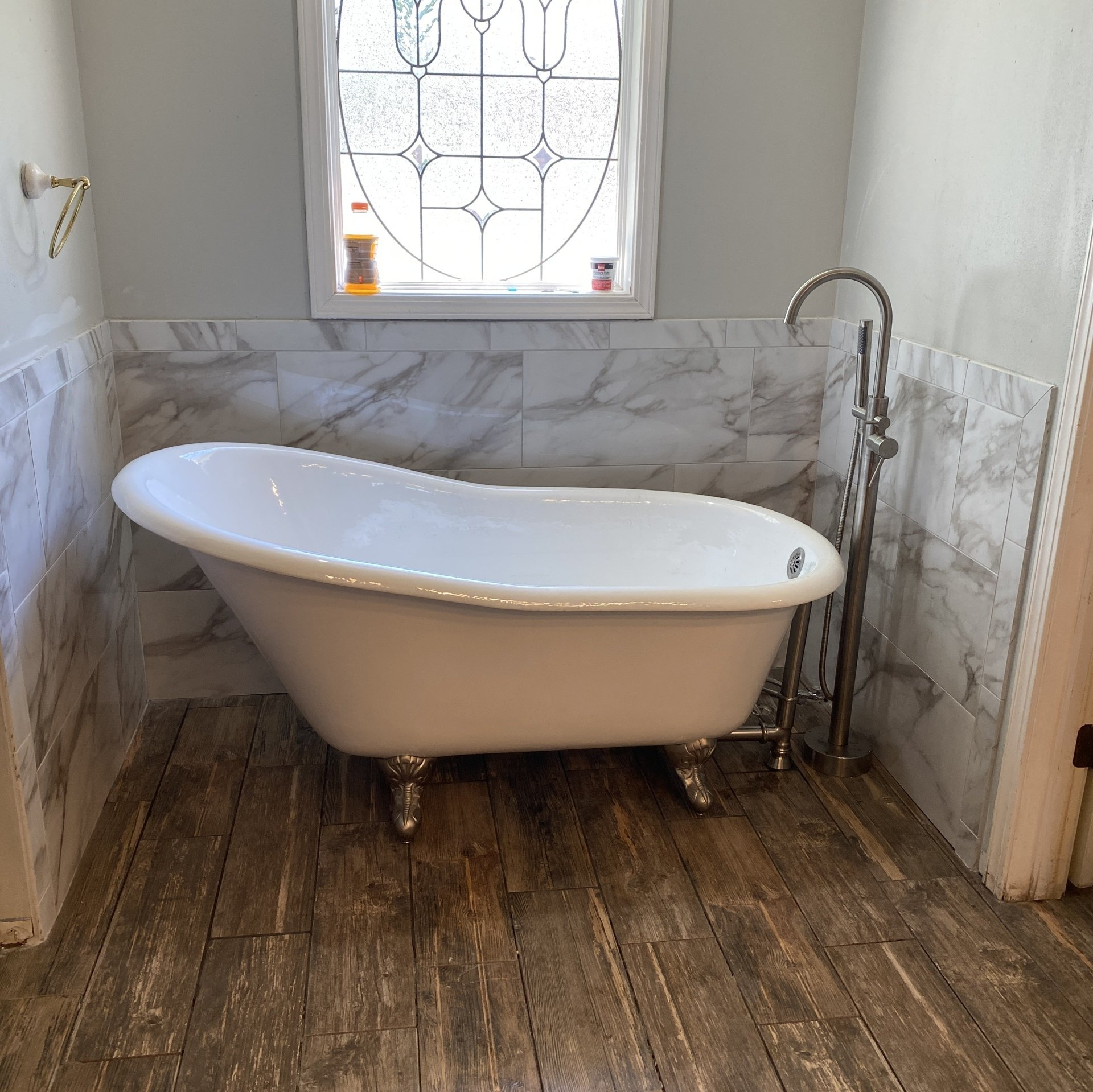 Bathtub, tile wainscot, tile flooring bathroom