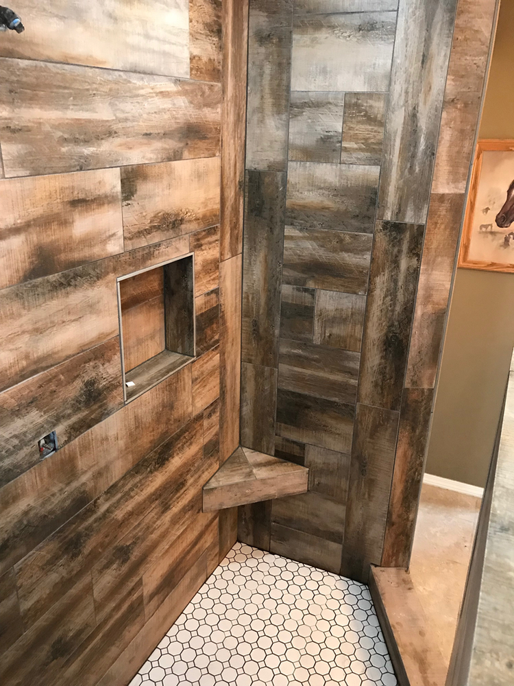 A shower with wooden walls and a white tile floor.