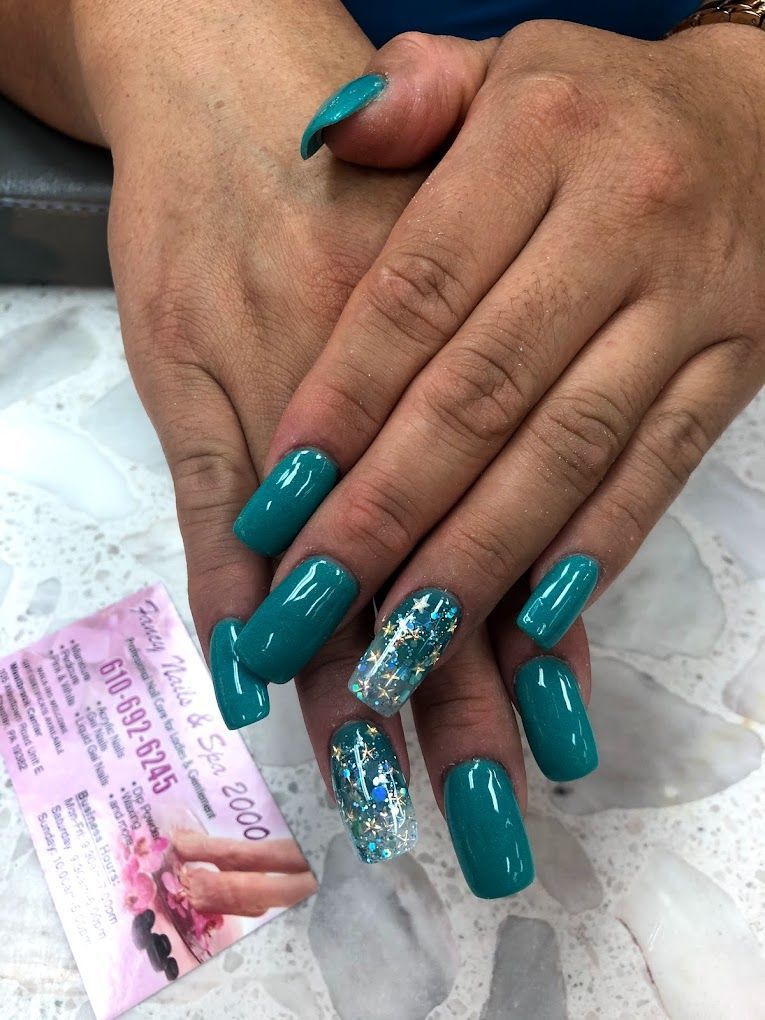 a woman 's hand with pink nails is holding a pink flower .