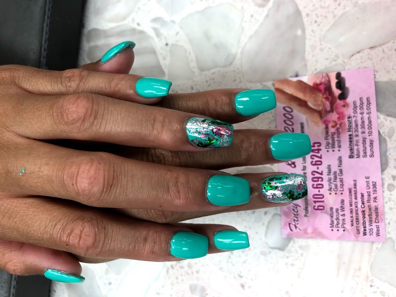 A close up of a woman 's nails with a phone number on it