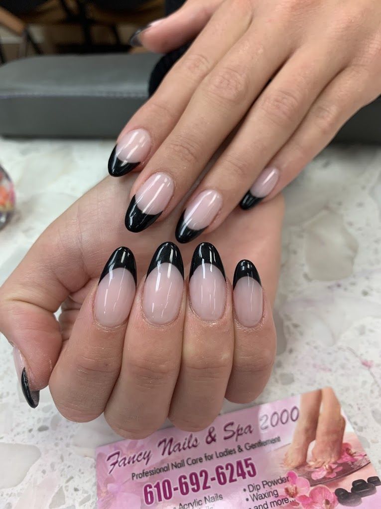 A close up of a woman 's nails with a black french manicure.
