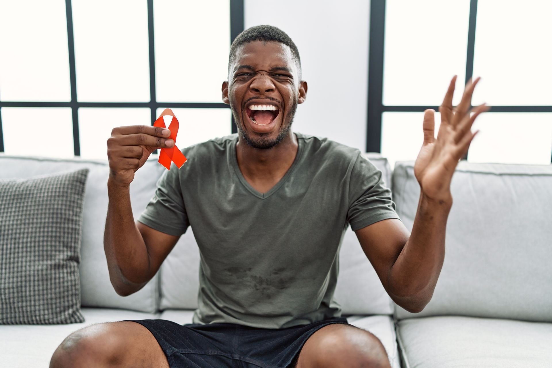 A man holding a HIV red ribbon