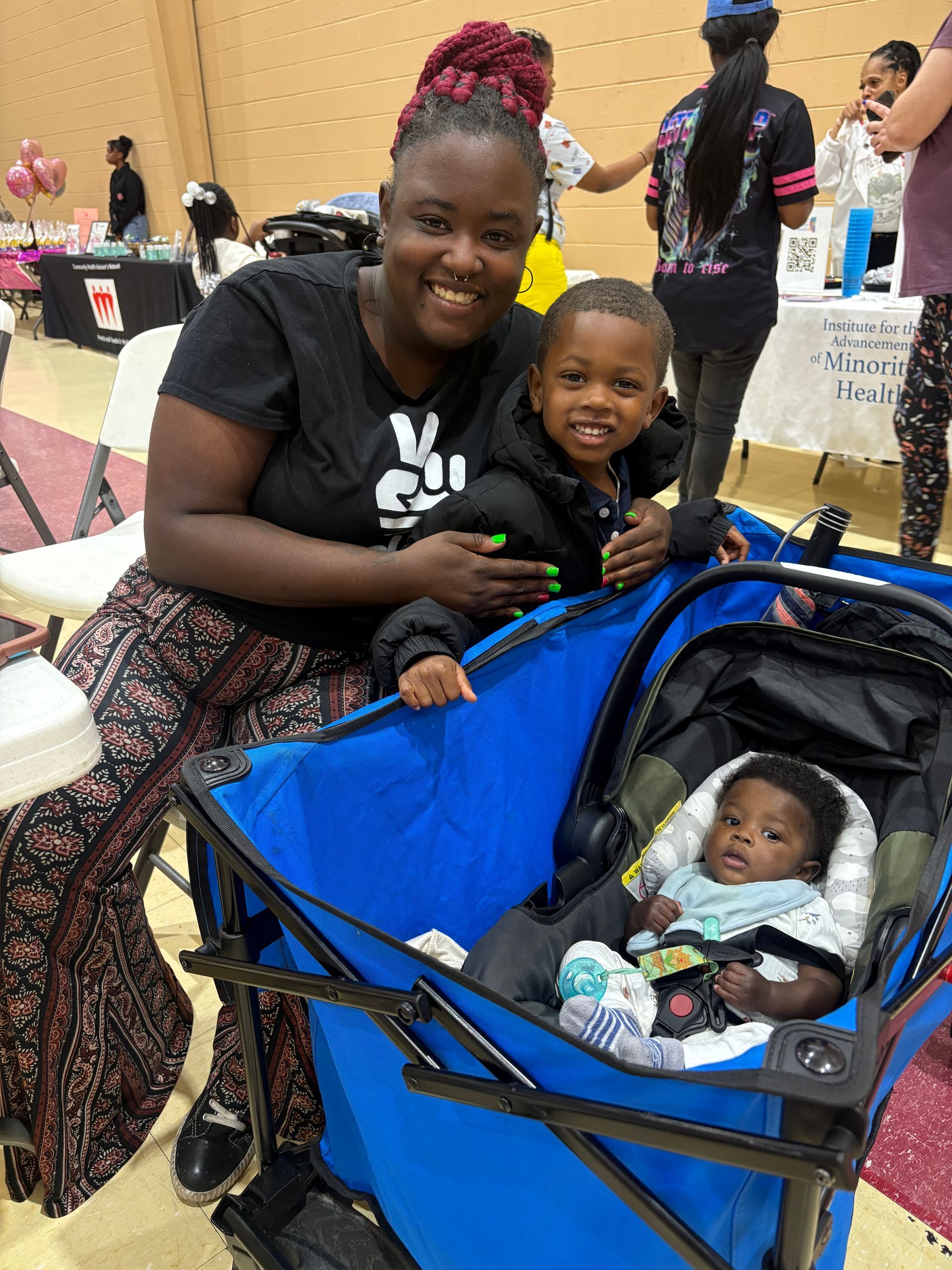 A smiling woman holding a joyful infant against her chest.