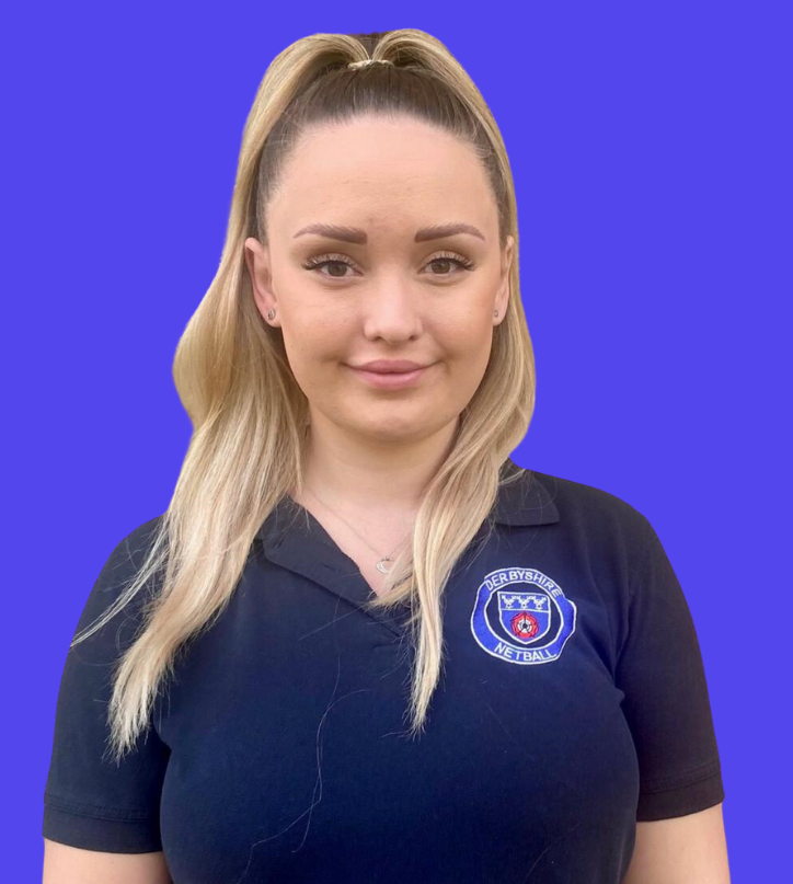 A woman wearing glasses is standing in front of a blue background.