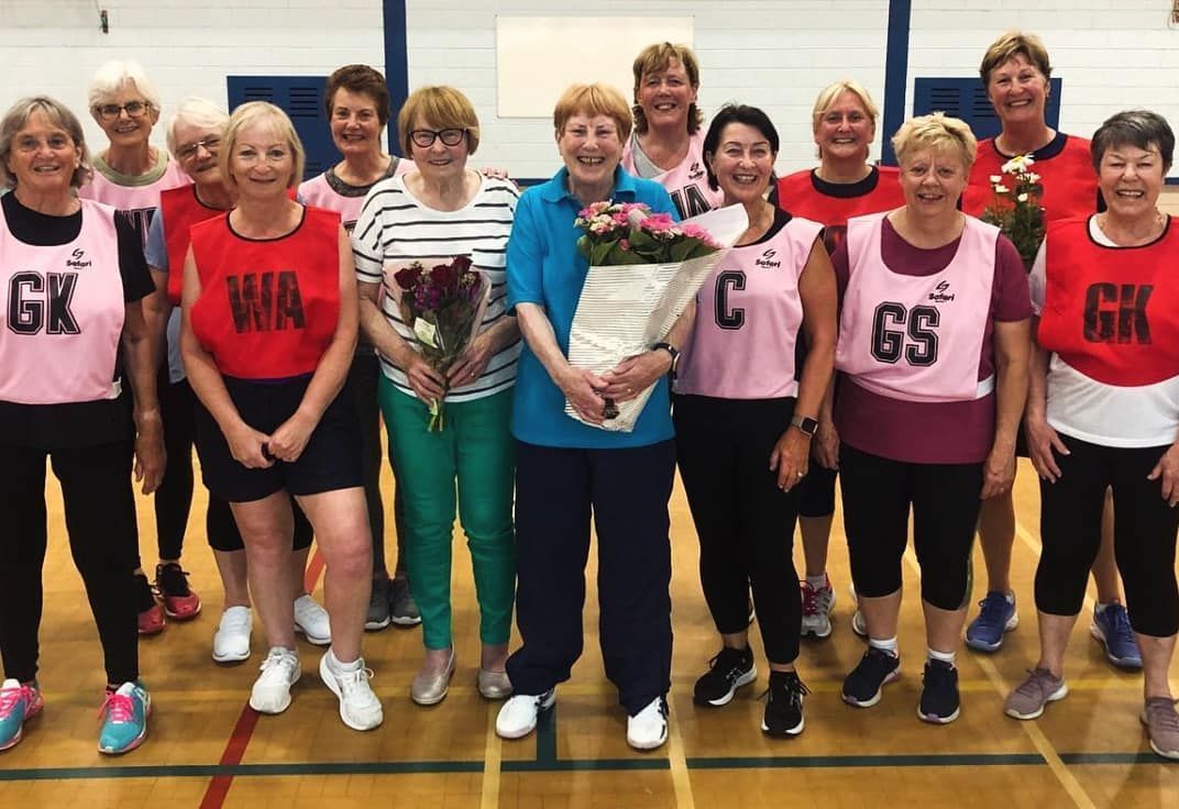 A group of women are posing for a picture in a gym.