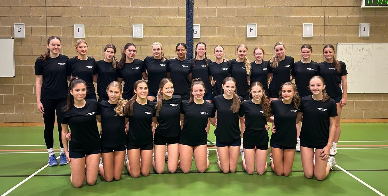 A group of girls are posing for a picture in a gym