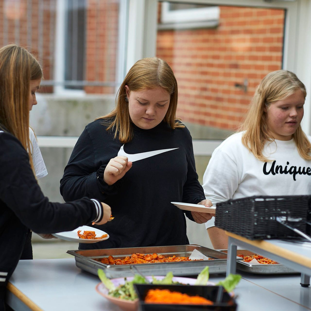 En kvinde iført en hvid skjorte, hvor der står unik