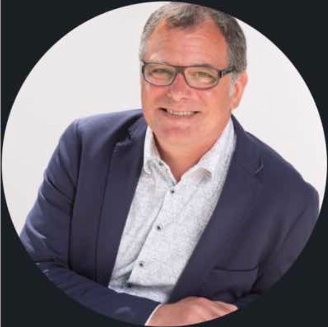 Un homme en costume et lunettes sourit en cercle.