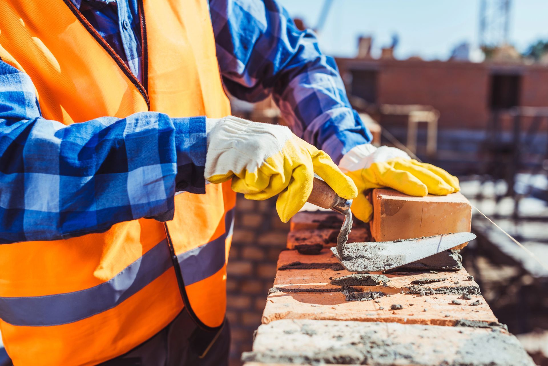 Un trabajador de la construcción está colocando ladrillos en una pared.