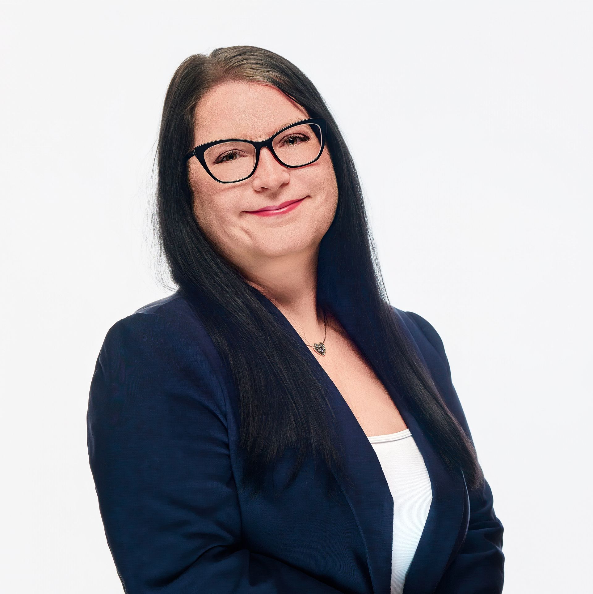 A woman in a gray jacket and black shirt is smiling for the camera.