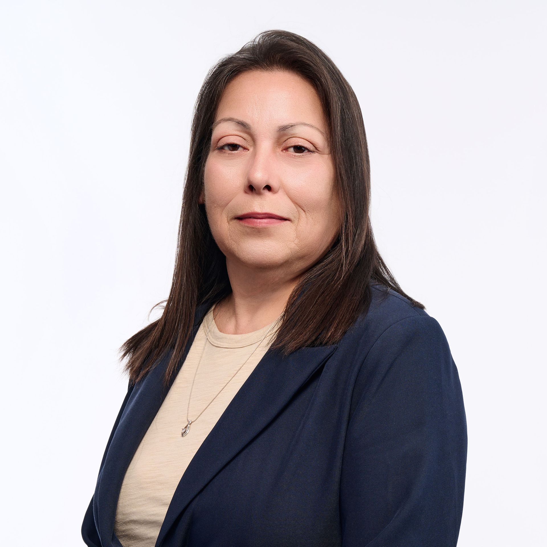A woman in a gray jacket and black shirt is smiling for the camera.