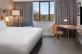 bedroom with lamp shade, side table with light, gray curtain