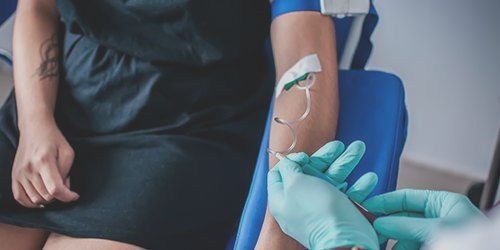 Une femme reçoit une injection dans son bras.