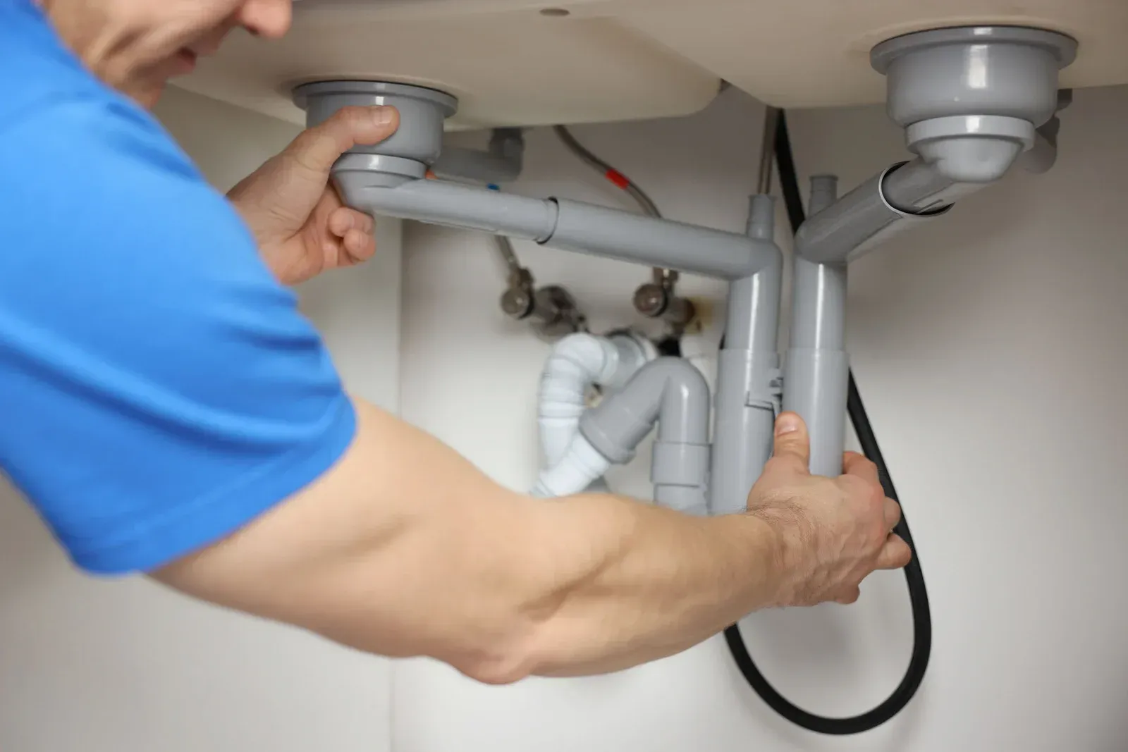 A man wearing a hard hat and goggles is standing in a room.