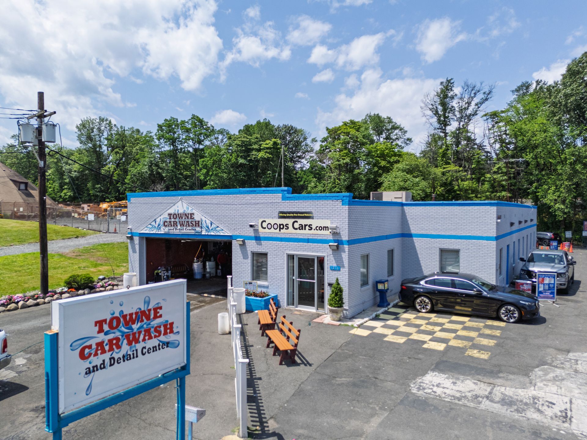 An aerial view of a car wash with cars parked in front of it