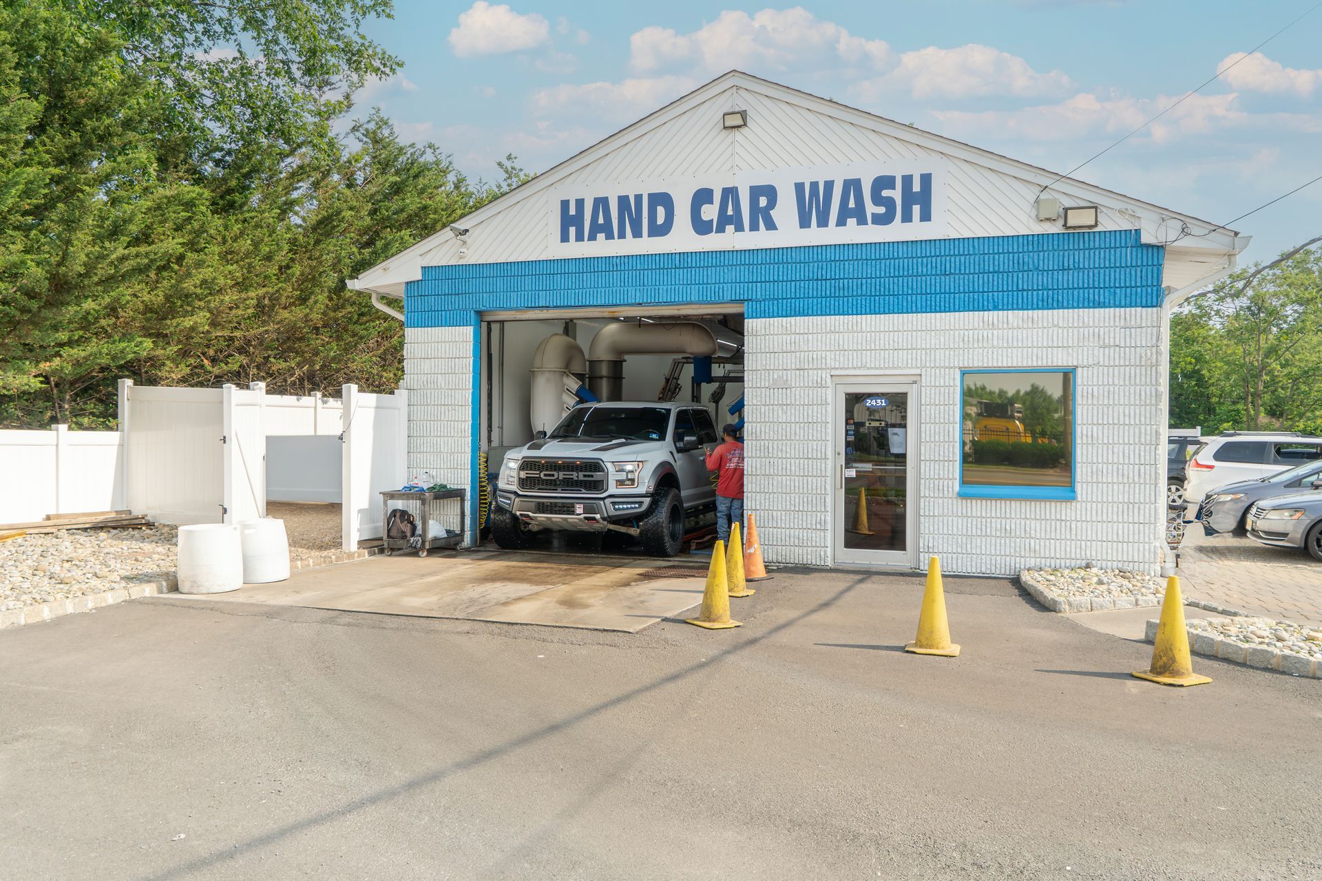 A car is being washed at a hand car wash.