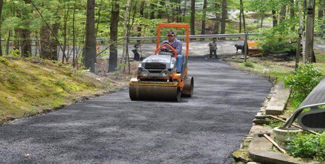 Man Driving Road Roller — Lunenburg, MA — Miller’s Paving, LLC