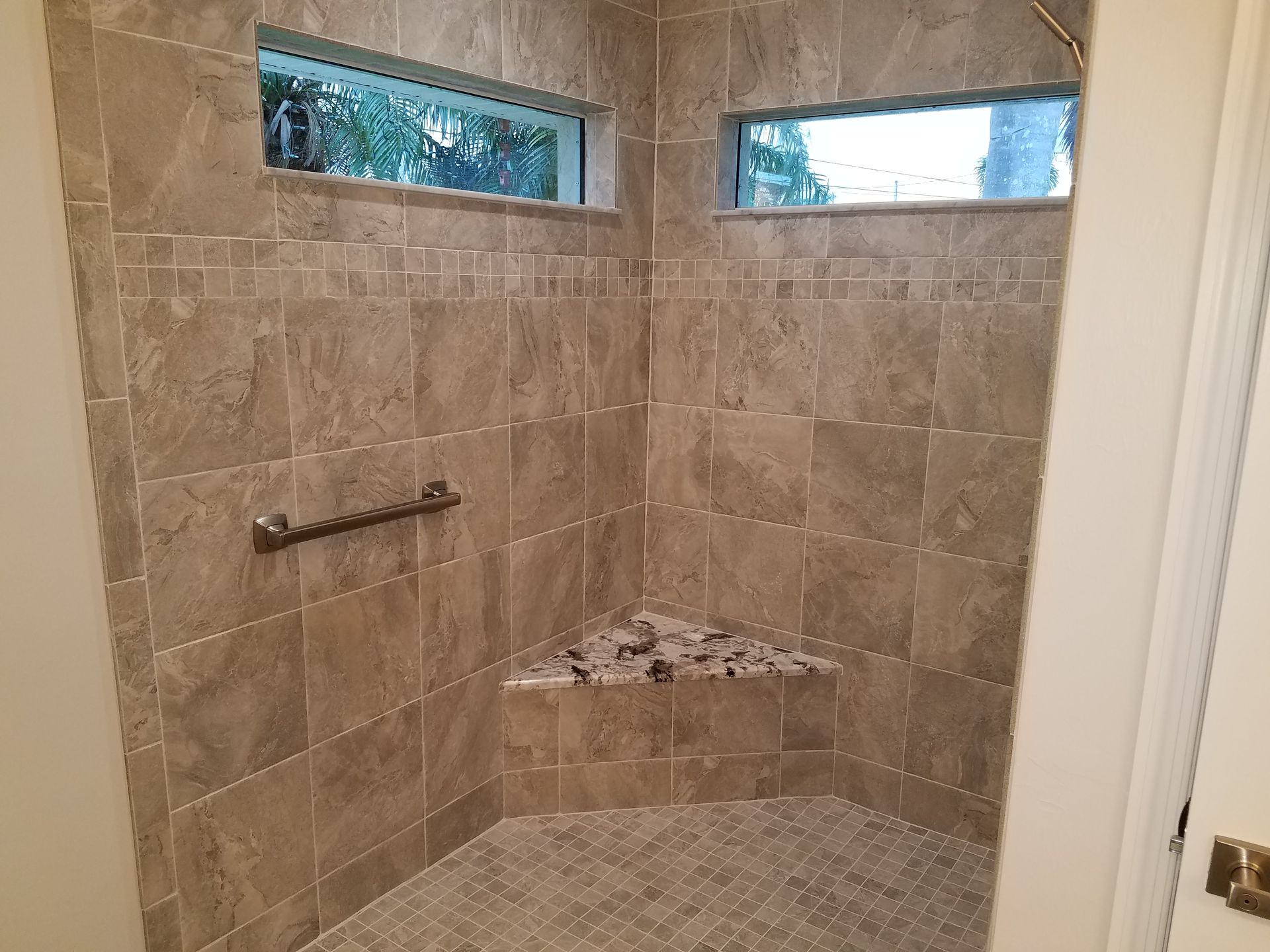 A bathroom with a walk in shower and a window.