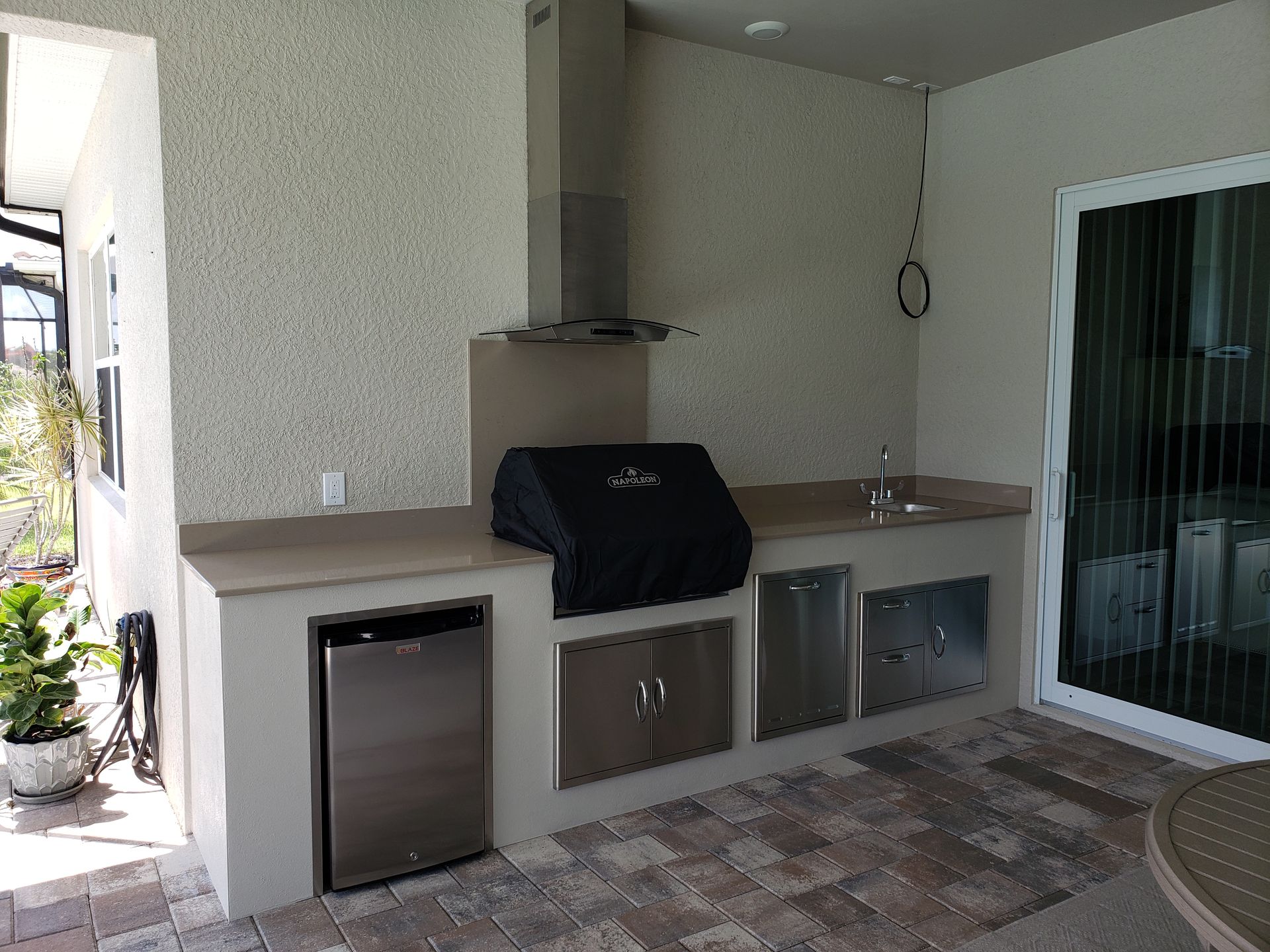 There is a grill and a refrigerator in the kitchen.