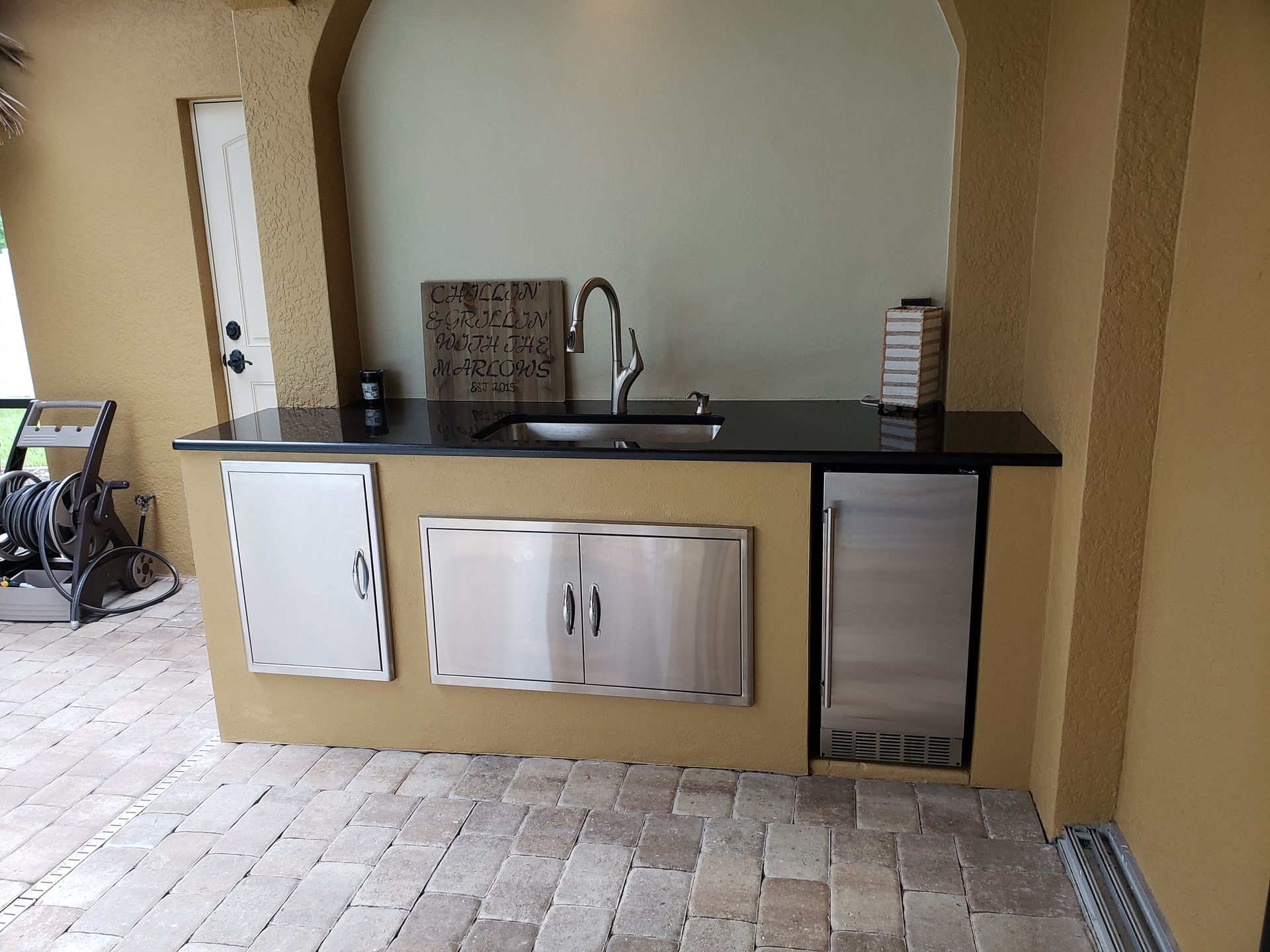 A kitchen with a sink , refrigerator and cabinets