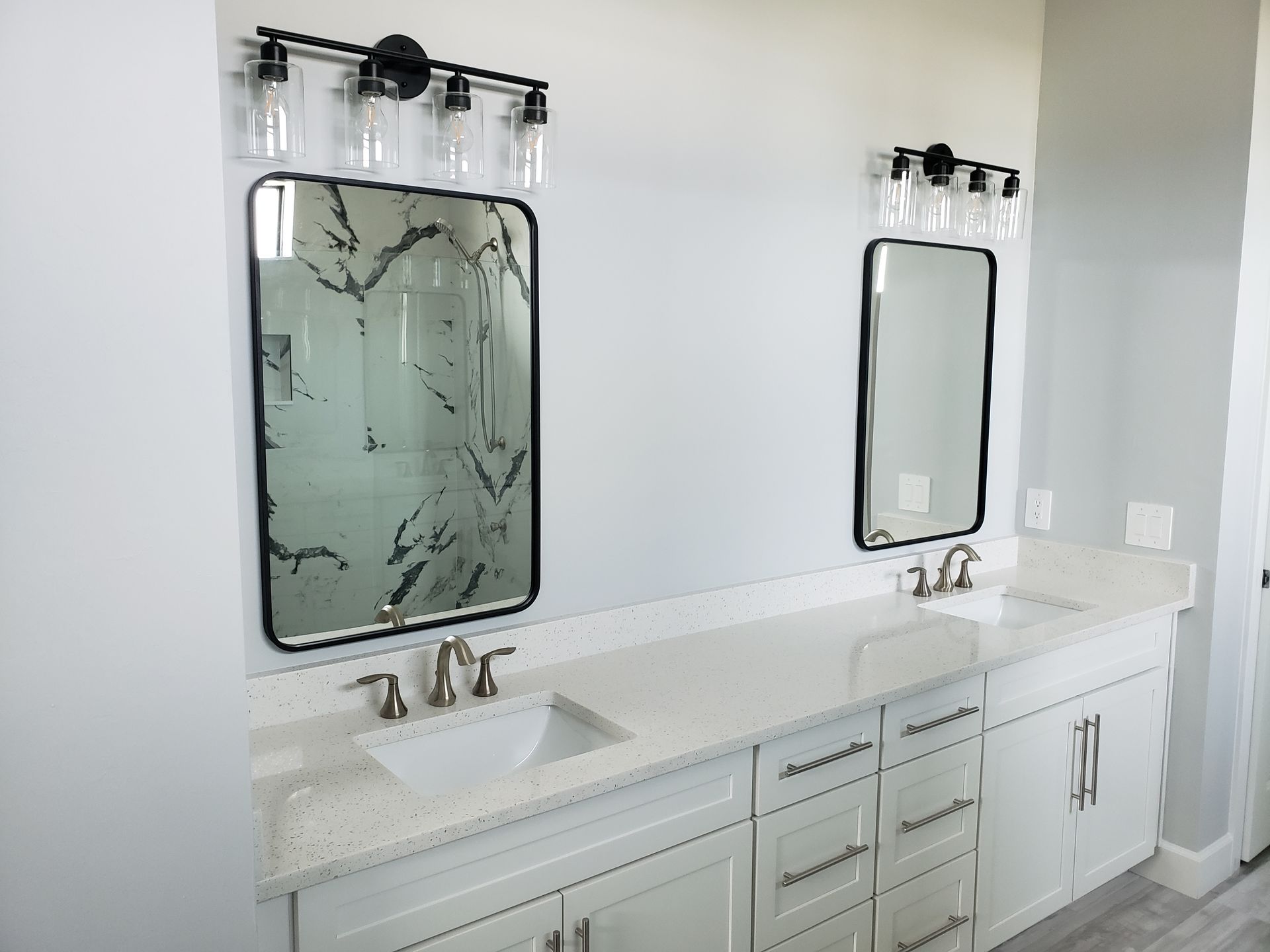 A bathroom with two sinks and two mirrors built by Blue Heron Construction Cape Coral