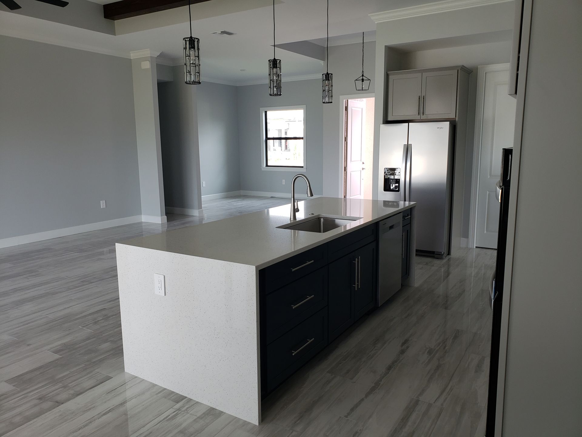 A kitchen with a large island and stainless steel appliances built by Blue Heron Construction Cape Coral