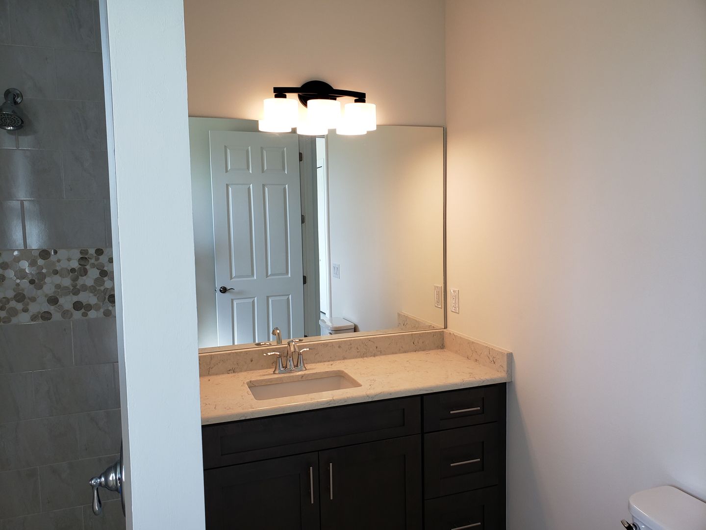 A bathroom with a sink , mirror and toilet