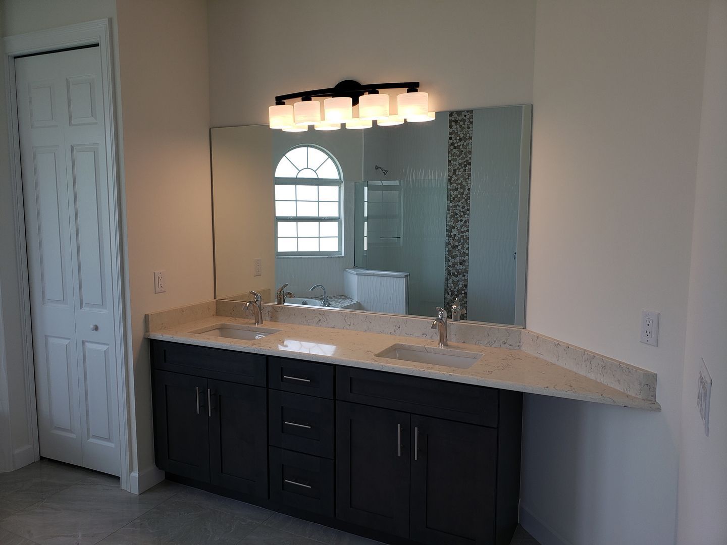 A bathroom with two sinks and a large mirror built by Blue Heron Construction Cape Coral