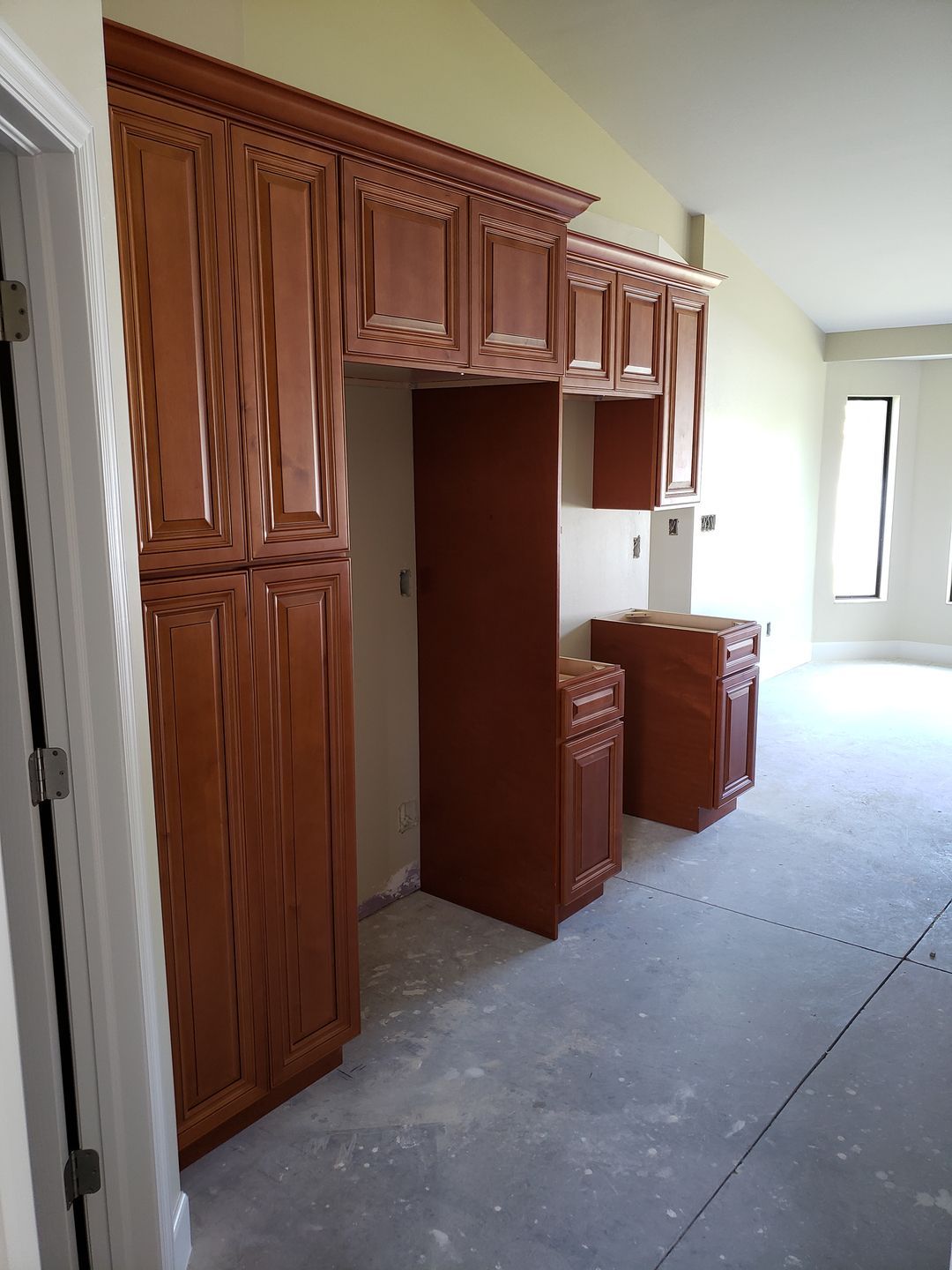 A kitchen with wooden cabinets and a refrigerator built by Blue Heron Construction Cape Coral