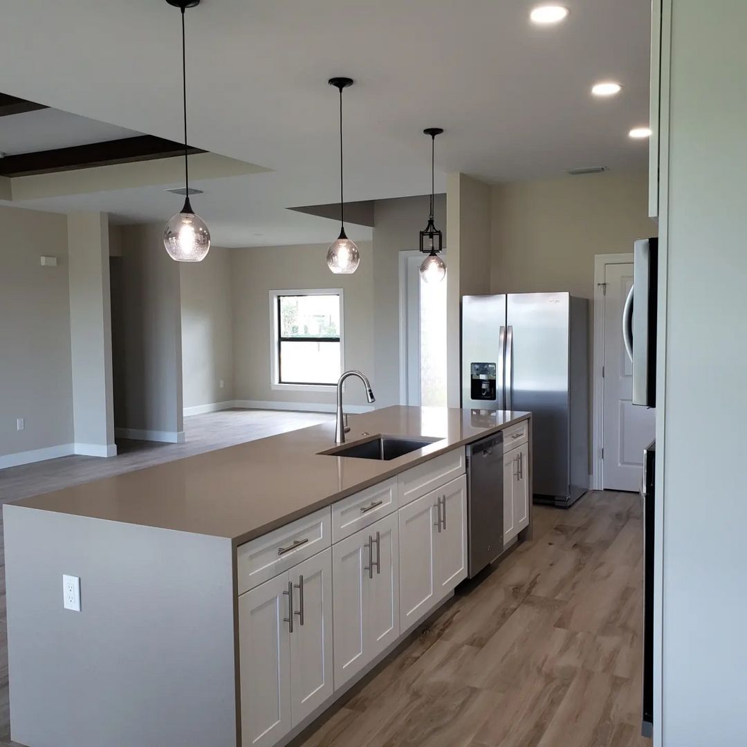A kitchen with stainless steel appliances and white cabinets built by Blue Heron Construction Cape Coral