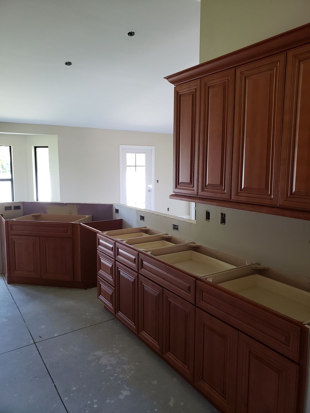 A kitchen under construction with wooden cabinets and counter tops built by Blue Heron Construction Cape Coral