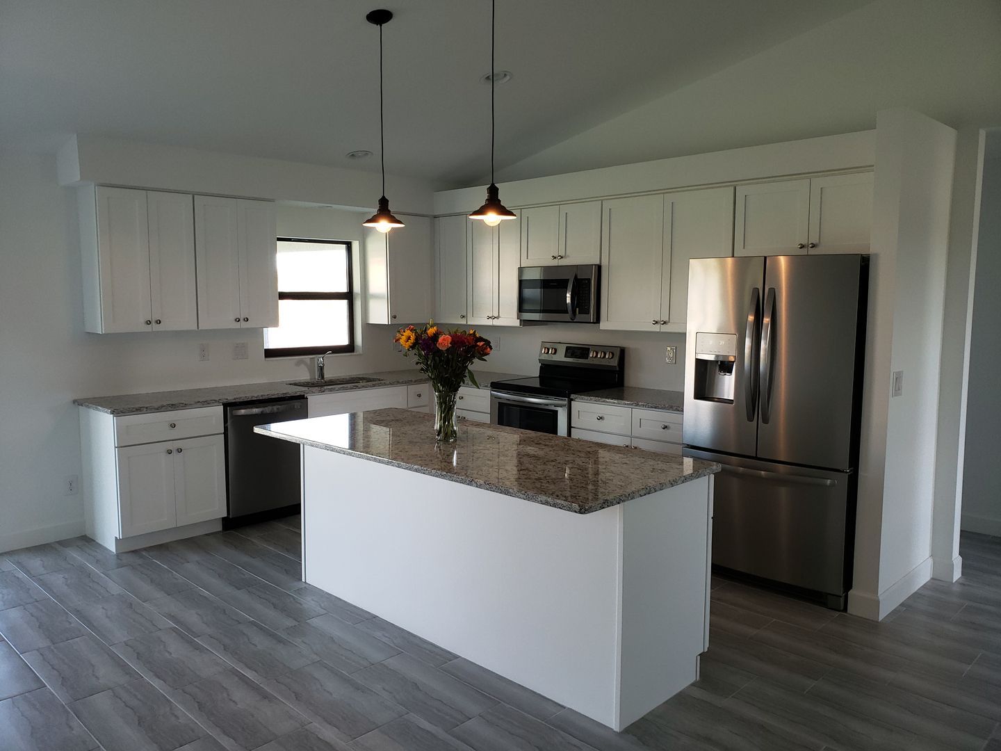 A kitchen with stainless steel appliances and granite counter tops built by Blue Heron Construction Cape Coral