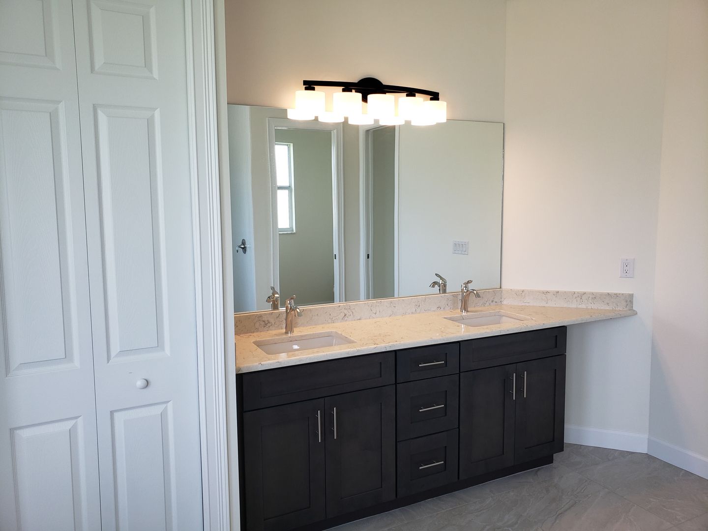 A bathroom with two sinks and a large mirror built by Blue Heron Construction Cape Coral