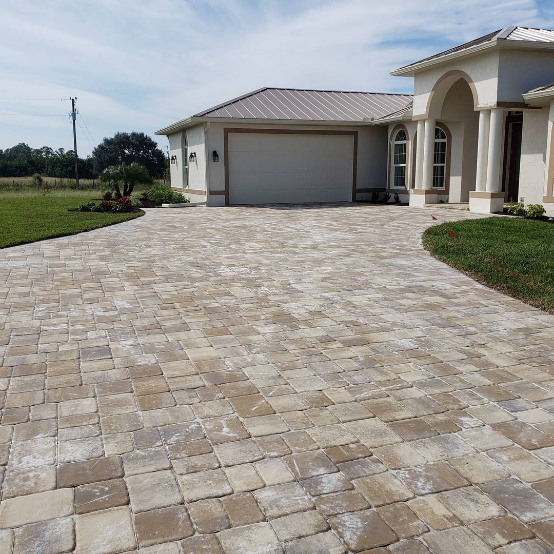 A brick driveway leading to a house with a garage door built by Blue Heron Construction Cape Coral