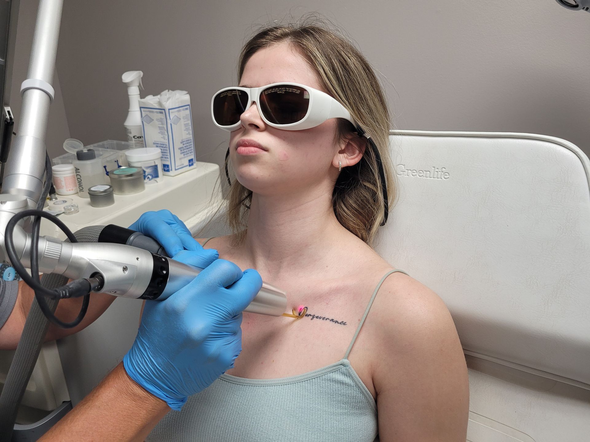 Woman receiving tattoo removal treatment on tattoo.