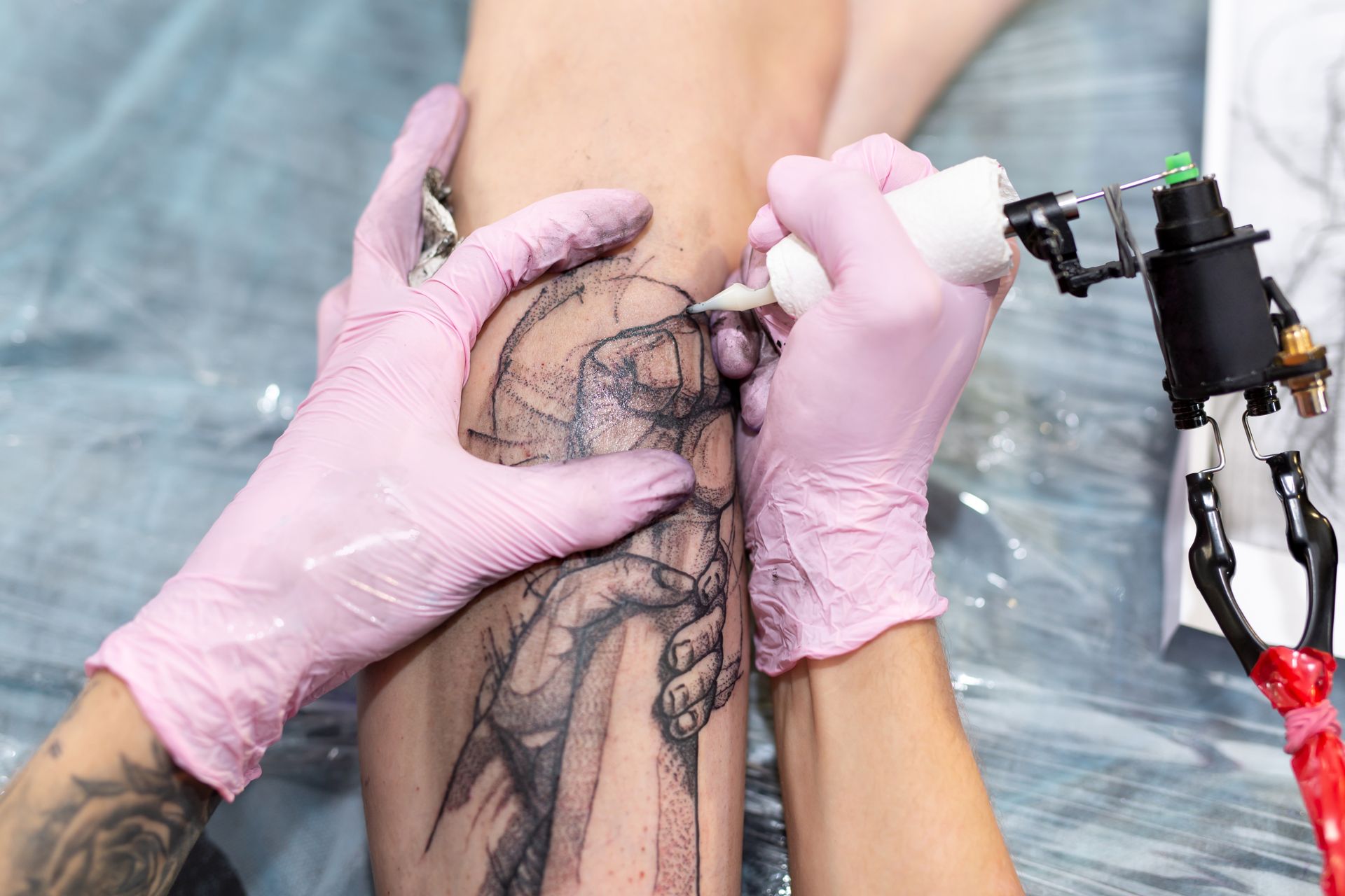 A woman is getting a tattoo on her leg.