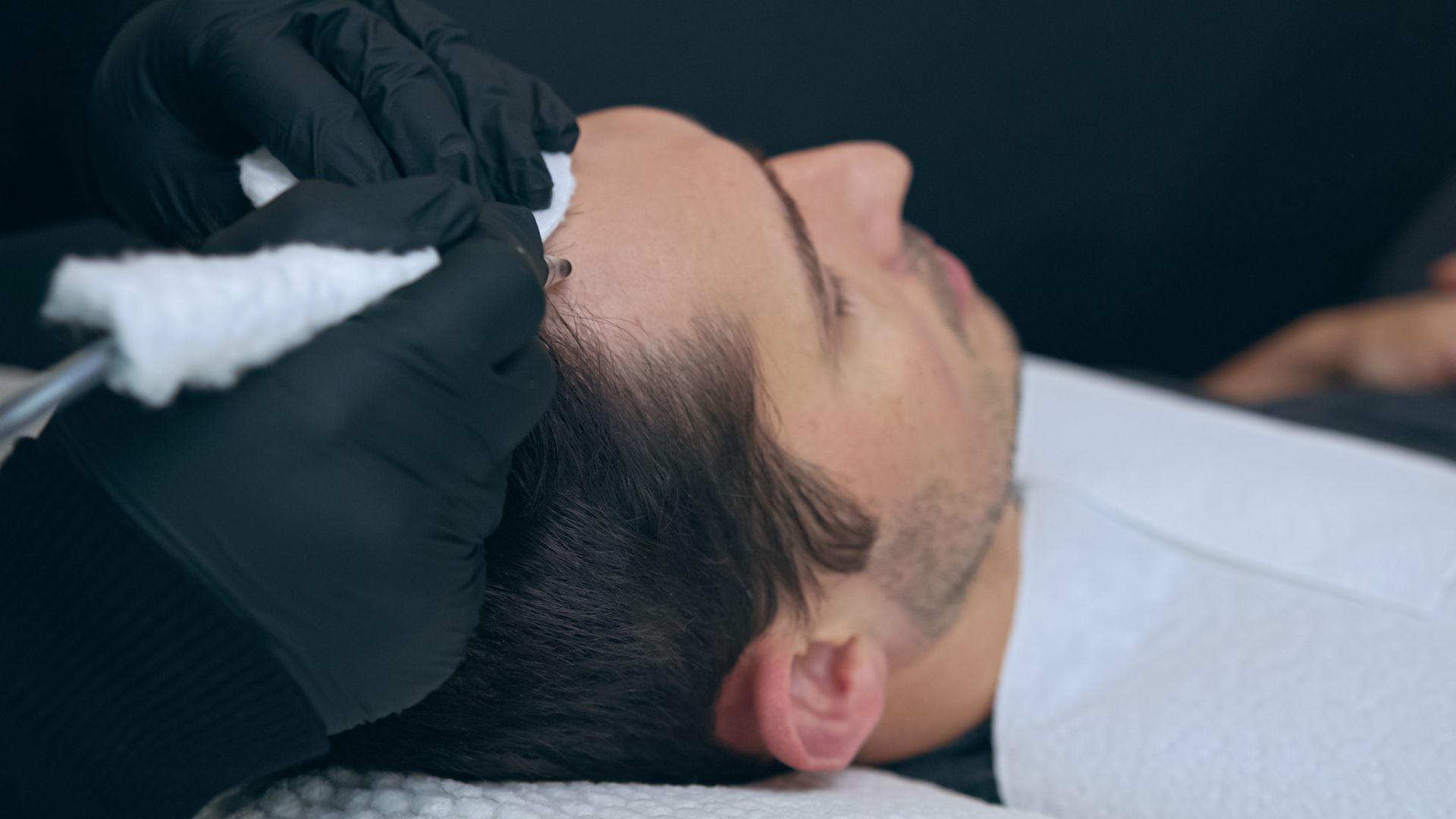 A man is getting a haircut at a barber shop.