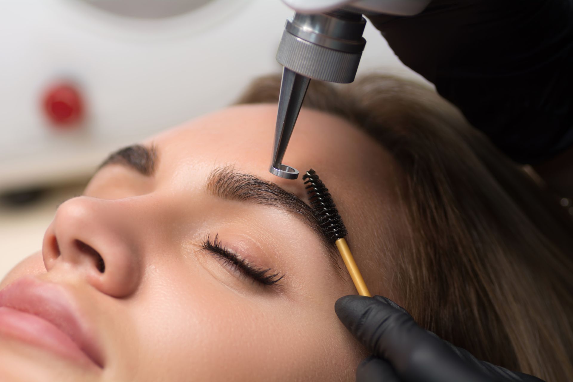 A woman is getting her eyebrows painted in a salon.