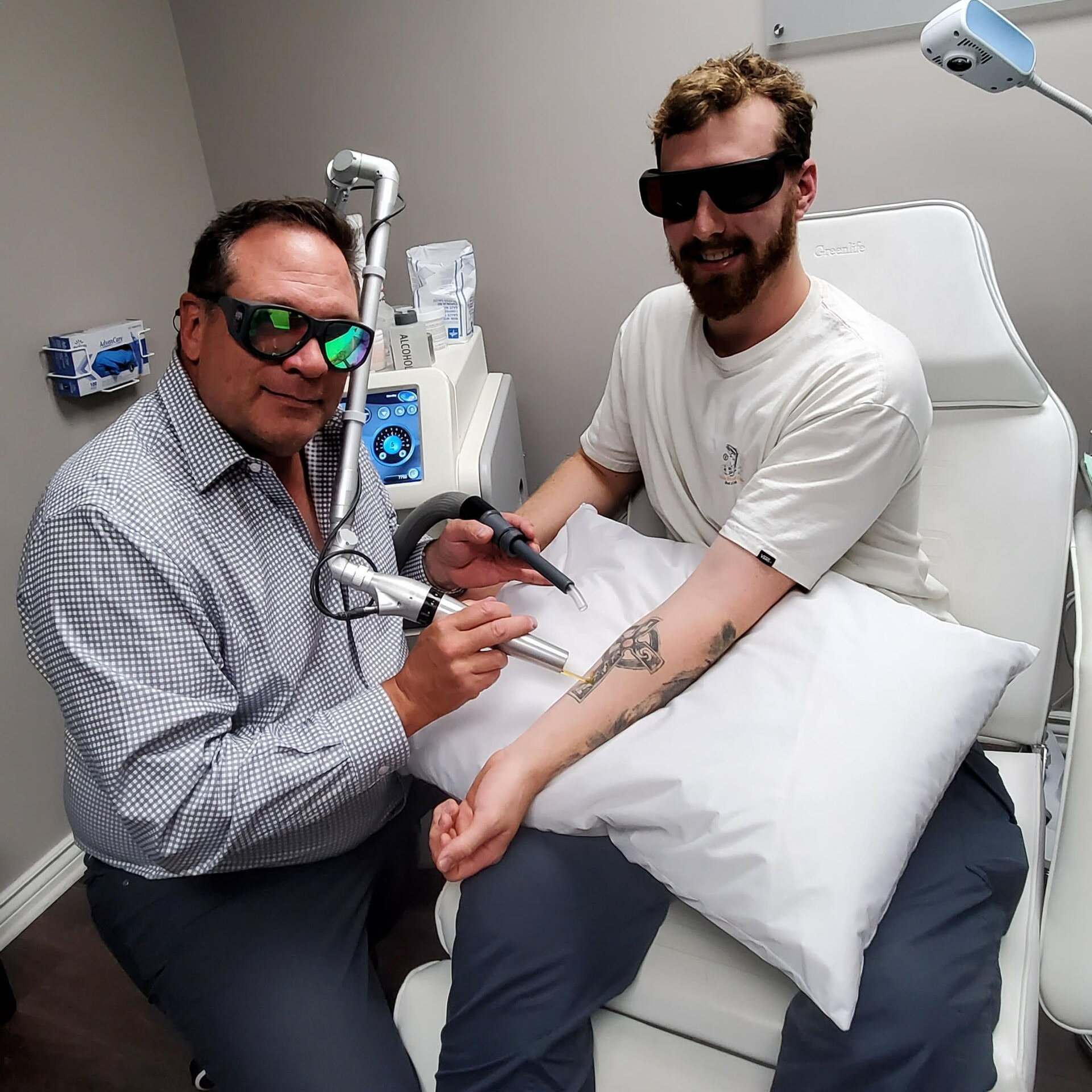 A man is getting a tattoo removed from his arm