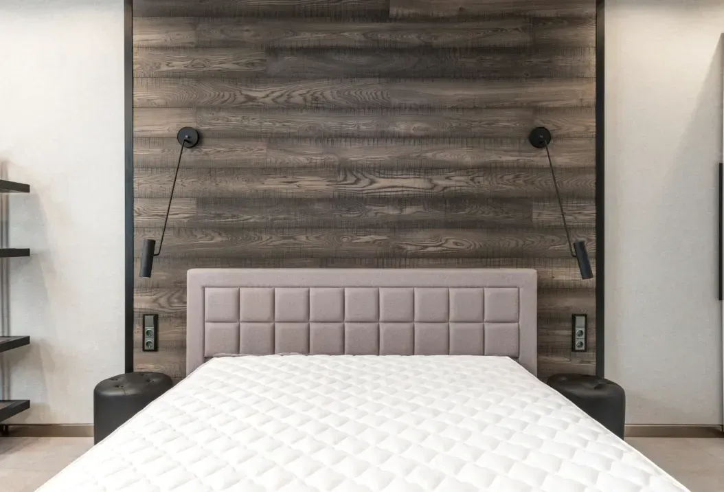 A bedroom with a bed and a wooden wall.