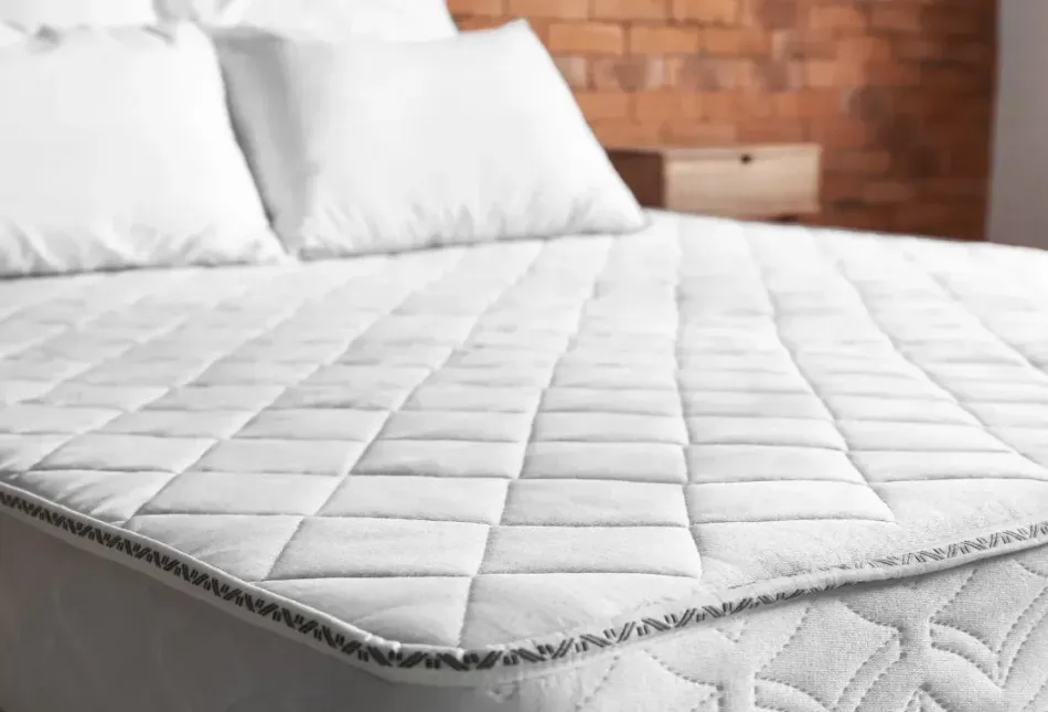 A bed with a mattress and pillows on it in a bedroom.