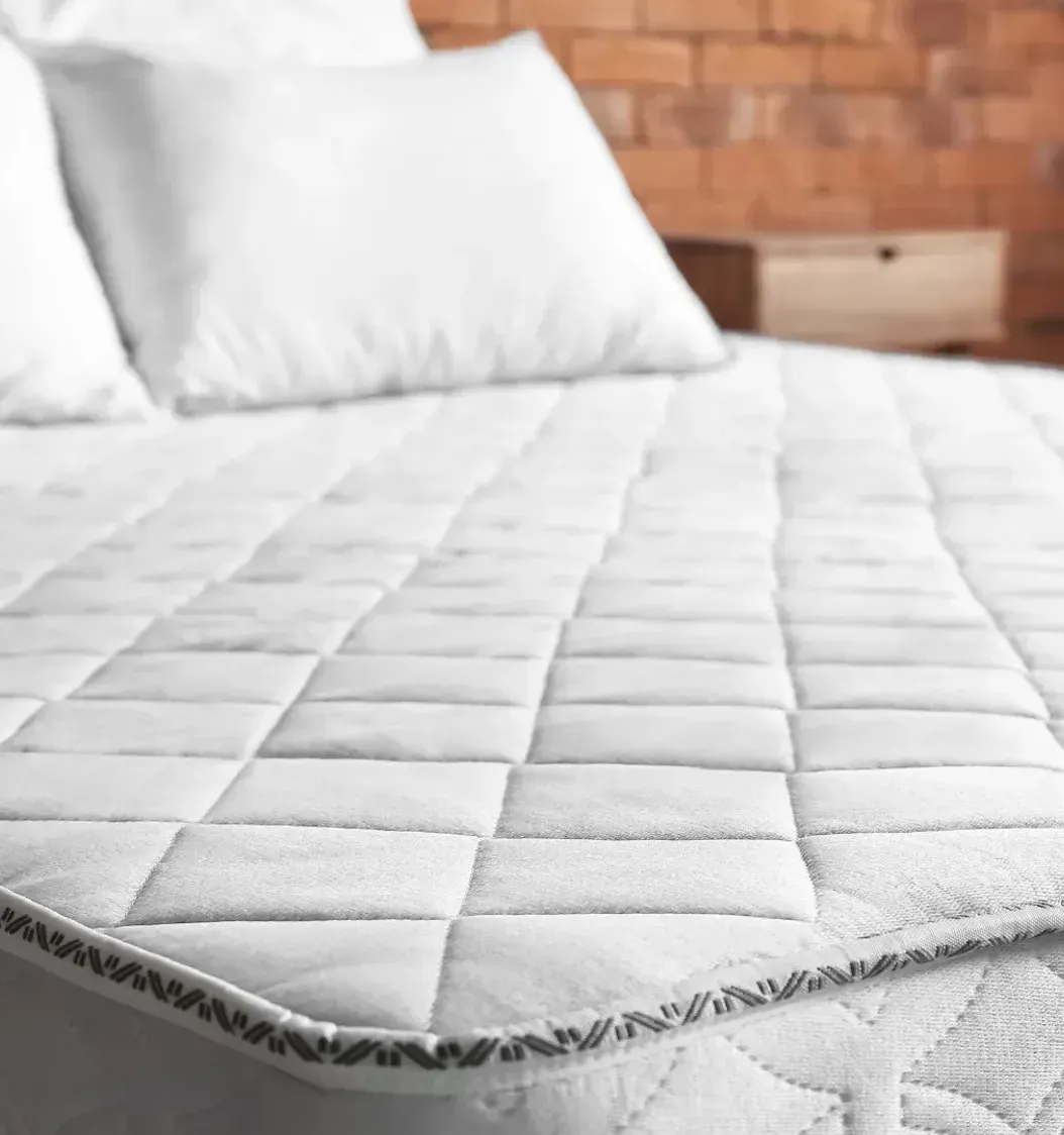 A bed with a mattress and pillows on it in a bedroom.