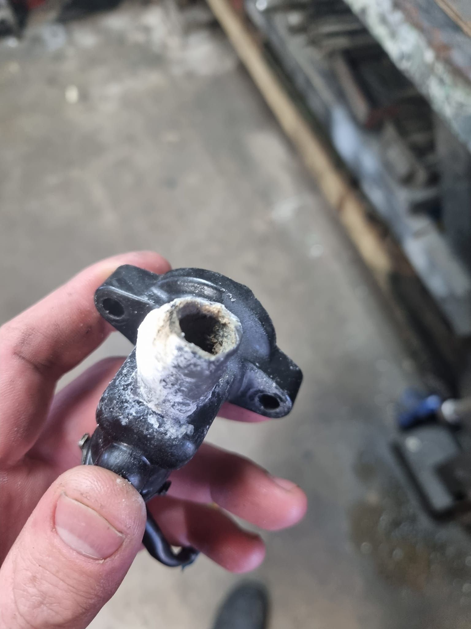 A boat engine is sitting on top of a pile of junk.