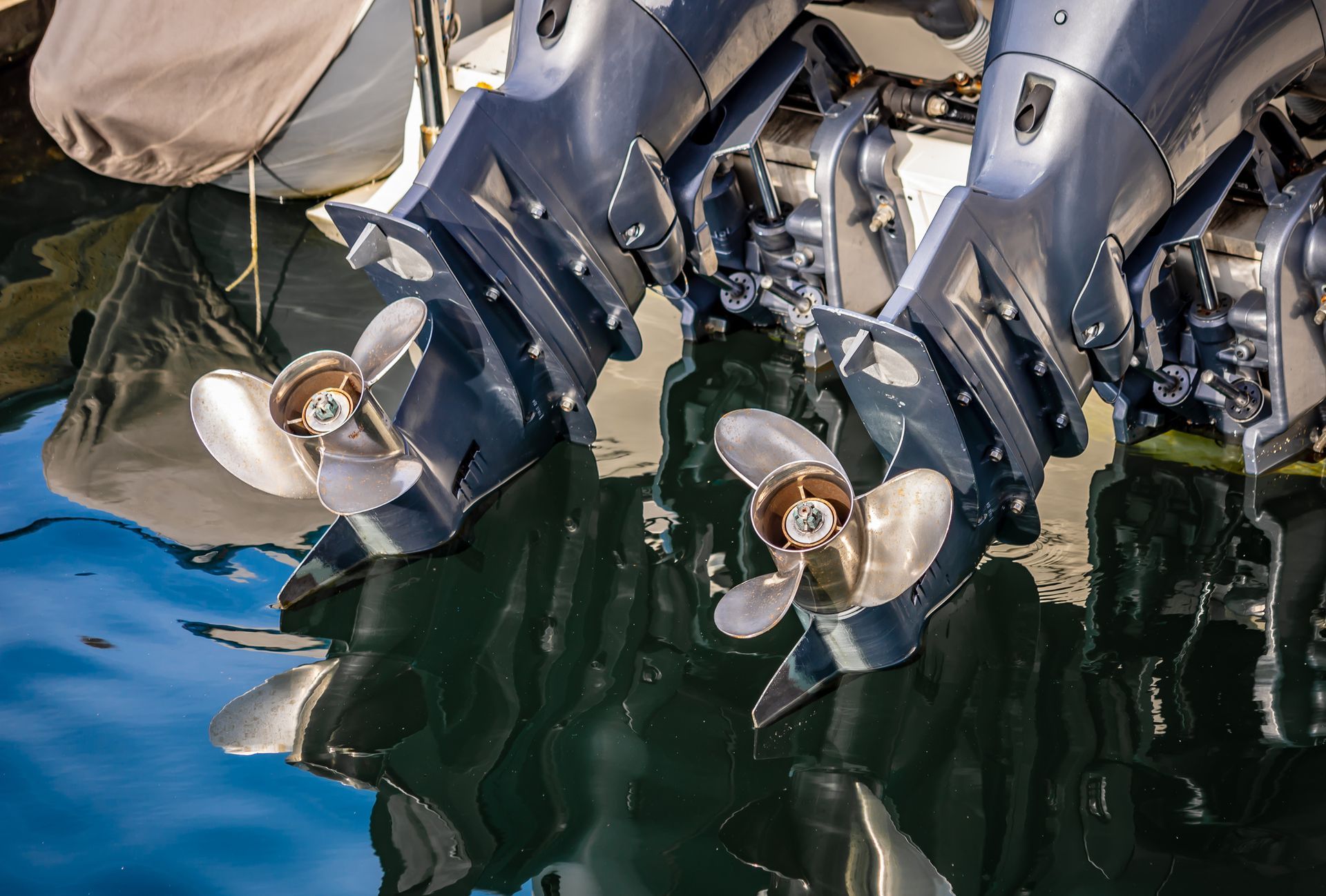 Two outboard motors are sitting on top of a boat in the water.